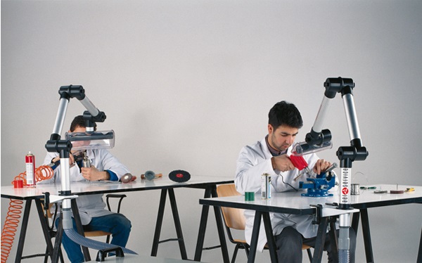 Two people sitting at workstations with AerService LAB arm in use - shows self-supporting arm, aluminium tubing, moveable arm, small size